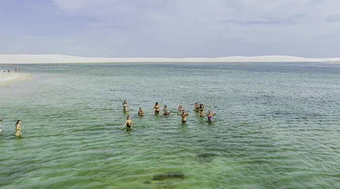 Grupo reunido dentro de uma lagoa de águas claras