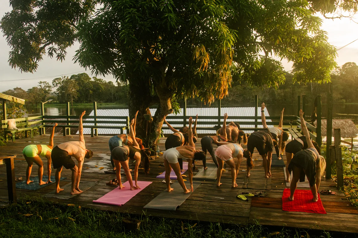 Grupo praticando yoga ao amanhecer durante o Retiro Acenda