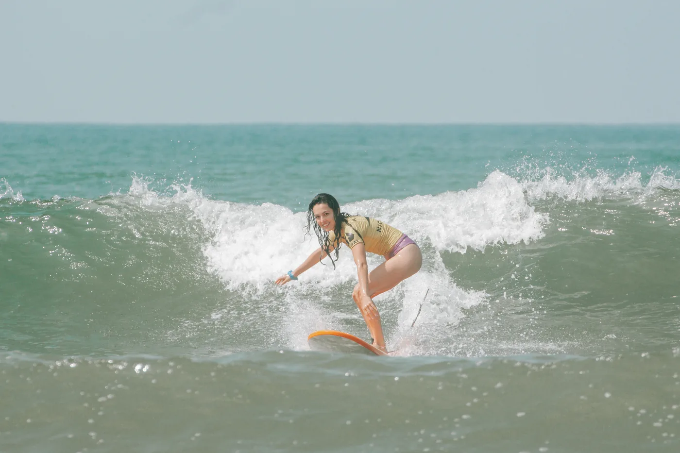 Mulher surfando uma onda em Pipa