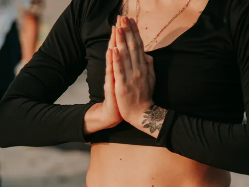 Mãos unidas diante do peito durante uma prática de yoga